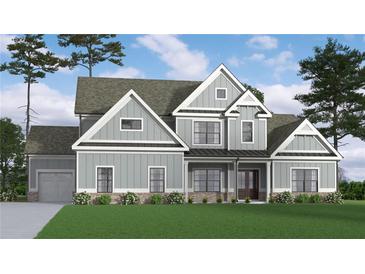 Charming two-story home featuring gray siding, complemented by a well-manicured lawn and lush landscaping at 1081 Holly Dr, Loganville, GA 30052