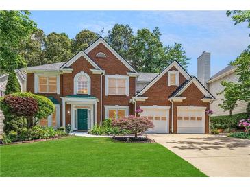 Charming two-story brick home featuring a well-manicured lawn and attached two car garage at 2835 Olde Town Park Dr, Norcross, GA 30071