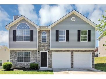 Charming two-story home with stone accents, black shutters, and a two-car garage at 2590 Carolina Rdg, Riverdale, GA 30296