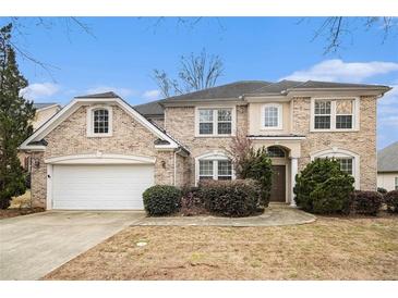 Charming two-story brick home with attached garage, manicured landscaping, and inviting entrance at 5658 Greensage Dr, Atlanta, GA 30349