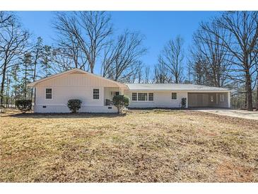 Charming single-story home with attached carport and freshly painted exterior, set on a spacious lot with mature trees at 9640 Cedar Grove Rd, Fairburn, GA 30213