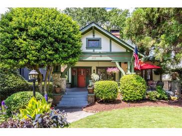 Charming home featuring a landscaped front yard with lush greenery, stone accents, and an inviting red door at 966 Blue Ridge Ne Ave, Atlanta, GA 30306