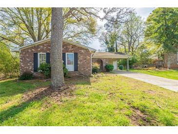 Charming brick home featuring a carport and a well-maintained front yard with mature trees at 2877 Kensington Way, Rex, GA 30273