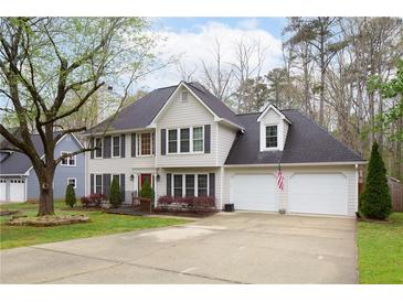 Charming two-story home with a well-manicured lawn, two-car garage, and classic architectural details at 1315 Bustling Sw Ln, Marietta, GA 30064