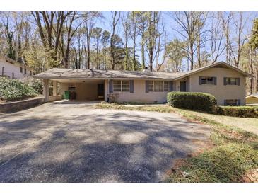 Charming one-story home with a carport and an expansive front yard with mature trees at 1470 Biltmore Ne Dr, Atlanta, GA 30329
