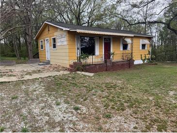 Charming, single-story home with a red front door and a partially landscaped front yard at 6127 Pinegrove Rd, Riverdale, GA 30274