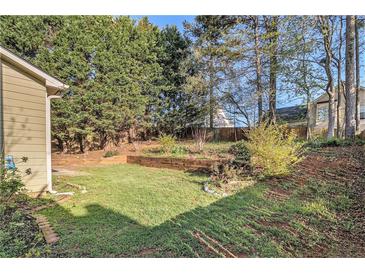 View of the backyard showing mature trees and landscaping at 3707 Mcguire Nw St, Kennesaw, GA 30144