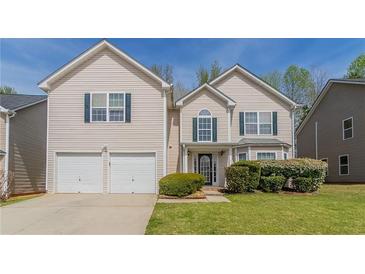 Charming two-story home featuring a well-manicured lawn, a two-car garage and traditional architecture at 4097 Rosebud Park Dr, Snellville, GA 30039
