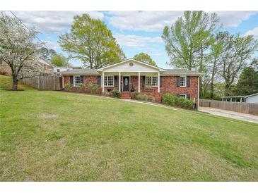 Charming brick home with a large front yard, mature trees, and welcoming front porch with white columns at 468 Windol Ct, Marietta, GA 30066