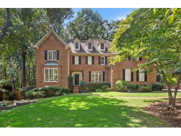 Charming brick home featuring a well-manicured lawn and mature trees at 788 Old Paper Mill Dr, Marietta, GA 30067