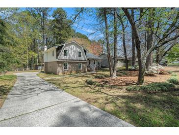 Charming two-story home featuring a brick foundation, vinyl siding, and a long driveway at 403 Red Oak Ln, Lawrenceville, GA 30046