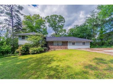 Charming single-Gathering home features a brick facade, well-maintained lawn, and lush landscaping at 1956 Joseph Ct, Decatur, GA 30032