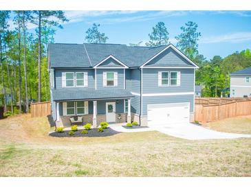 Two-story home with gray siding, white trim, an attached garage and well-manicured lawn in a suburban setting at 284 Bryson Lake Cir, Douglasville, GA 30134