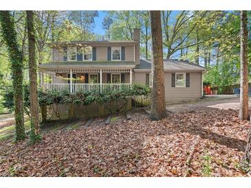 Charming two-story home with a cozy front porch and mature trees at 5269 Blue Grass Ln, Sugar Hill, GA 30518