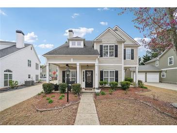 Charming two-story home featuring a welcoming front porch, landscaped yard, and classic architectural details at 3800 Lake Pass Ln, Suwanee, GA 30024