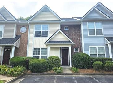 Charming townhome featuring a well-maintained lawn and a welcoming front entrance at 801 Old Peachtree Nw Rd # 15, Lawrenceville, GA 30043
