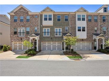 Charming townhome exterior featuring a brick facade, multi-car garage, and inviting entrance at 2048 Violet Lane, Brookhaven, GA 30319