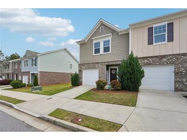 Charming townhome with a one-car garage, landscaped yard, and inviting front entrance at 2051 Wildflower Way, Conyers, GA 30012