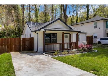 Charming renovated cottage home featuring a freshly painted exterior, inviting porch, and well-manicured front yard at 1318 Graymont Sw Dr, Atlanta, GA 30310