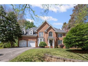Charming brick home featuring a manicured lawn, arched entry, and attached two-car garage at 5628 Fallsbrook Nw Knl, Acworth, GA 30101