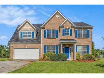 Charming two-story brick home with blue shutters and well-manicured lawn at 1027 Fellowship Rd, Fairburn, GA 30213