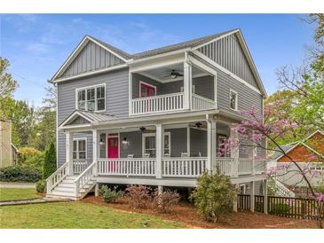 Charming two-story home with a inviting porch and eye-catching pink doors at 791 Woodland Se Ave, Atlanta, GA 30316