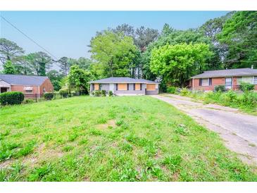 Modest single-story home with a spacious front yard and a long driveway, nestled among mature trees at 1753 Thomas Ter, Decatur, GA 30032