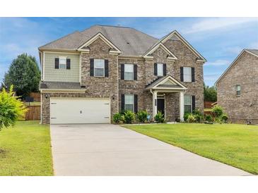 Charming two-story brick home with well-maintained lawn and attached two-car garage at 312 Amble Side, Mcdonough, GA 30252