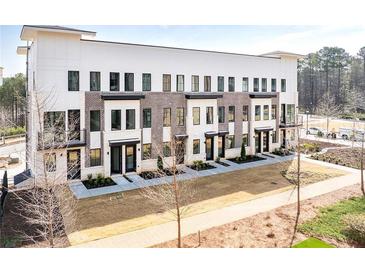 Modern townhome exterior with brick and siding, featuring well-maintained landscaping at 7210 Summit Pl, Alpharetta, GA 30009