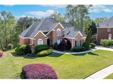 Beautiful brick home featuring lush landscaping and mature trees in a desirable neighborhood at 1450 Chadberry Way, Lawrenceville, GA 30043