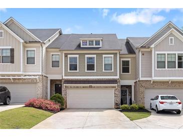 Charming townhome with a two-car garage, lovely landscaping, and inviting curb appeal at 207 Magnolia Creek Way, Woodstock, GA 30188