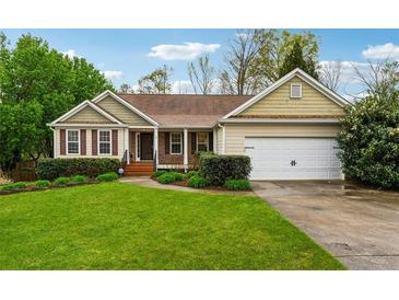Charming single-story home with a well-manicured lawn, beautiful landscaping, and an attached two-car garage at 392 Beranda Cir, Douglasville, GA 30134