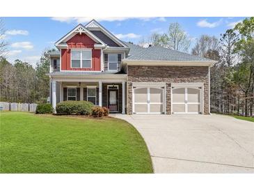 Charming two-story home featuring a manicured lawn, brick accents, and a two-car garage, all under a sunny sky at 453 Clematis Ct, Temple, GA 30179