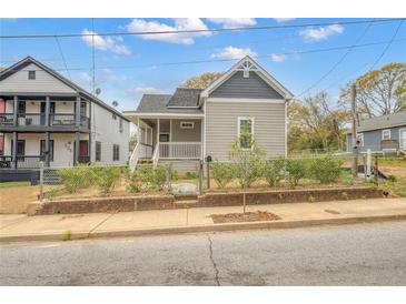 Charming craftsman-style home with gray siding, fenced yard, and inviting front porch at 510 James P. Brawley Dr. Nw Dr, Atlanta, GA 30318