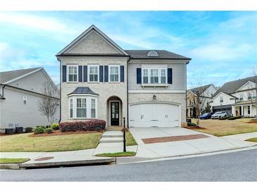 Charming two-story home featuring a two-car garage, a landscaped yard, and a mix of brick and siding exterior at 6585 Creekview Cir, Duluth, GA 30097