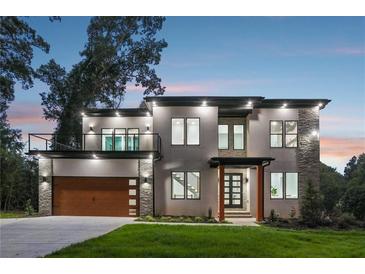 Stunning modern home featuring a balcony, stone accents, and a seamlessly integrated two-car garage at 1604 Niskey Lake Sw Rd, Atlanta, GA 30331