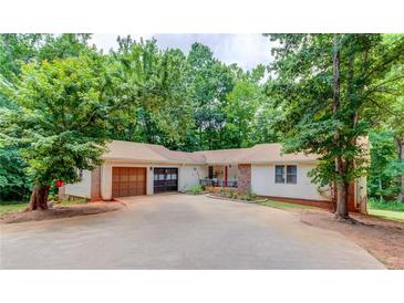 Charming ranch-style home with a two-car garage, mature trees, and a spacious driveway at 322 Kibbee Rd, Mcdonough, GA 30252