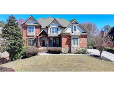 Stately brick and siding home with manicured lawn and mature landscaping at 2505 Weber Heights Way, Buford, GA 30519