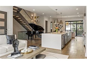 Open-concept living space featuring a modern kitchen, staircase, and grand piano at 904 Lenox Ne Blvd, Atlanta, GA 30324