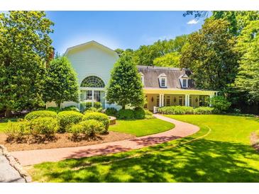 Stunning exterior view of a white home with a brick walkway, lush landscaping, and a welcoming front porch at 468 W Paces Ferry Rd, Atlanta, GA 30305
