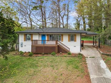 Charming, renovated home with a bright blue front door, shutters, and a covered carport at 2740 Flagstone Se Dr, Atlanta, GA 30316
