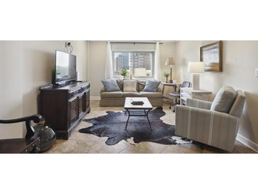 Cozy living room featuring a comfortable sofa, accent chair, and decorative rug at 2285 Peachtree Ne Rd # 1207, Atlanta, GA 30309