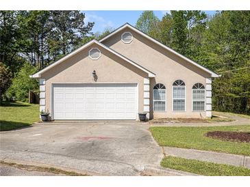 Charming single-story home with a two-car garage and a well-maintained front yard in a suburban setting at 165 Gingercake Ct, Fayetteville, GA 30214