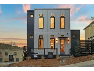 Modern two-story home featuring a sleek design with vertical siding and large windows at 180 Railroad St, Canton, GA 30114