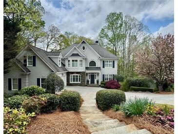 Elegant two-story home with a manicured front yard and a charming stone pathway at 460 Laurel Chase Ct, Atlanta, GA 30327