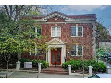 Charming two-story brick building featuring symmetric design, a red door, and manicured greenery at 733 Frederica Ne St # 12, Atlanta, GA 30306