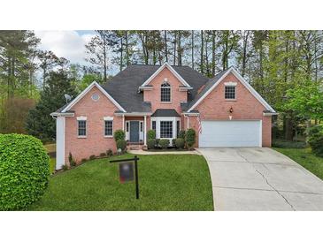 Beautiful two-story brick home with a well-manicured lawn and a two-car garage on a sunny day at 740 Trillium Ln, Lilburn, GA 30047