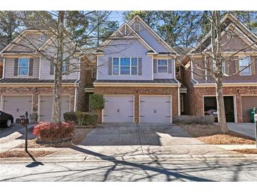 Charming townhome with brick and siding exterior, two-car garage, and well-maintained landscaping at 2930 Smith Ridge Trce, Peachtree Corners, GA 30071