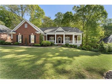 Charming single-story brick home with a welcoming front porch and manicured lawn at 3100 Templeton Ln, Loganville, GA 30052