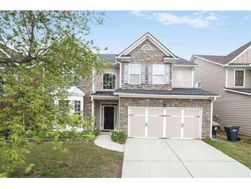 Charming two-story home with stone accents, two-car garage, and beautifully landscaped front yard at 350 Marble Springs Rd, Lilburn, GA 30047
